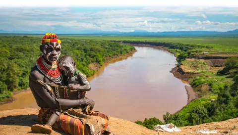 Kara parent and child sitting along the bank of the Omo River. Copyright: Kelly Fogel