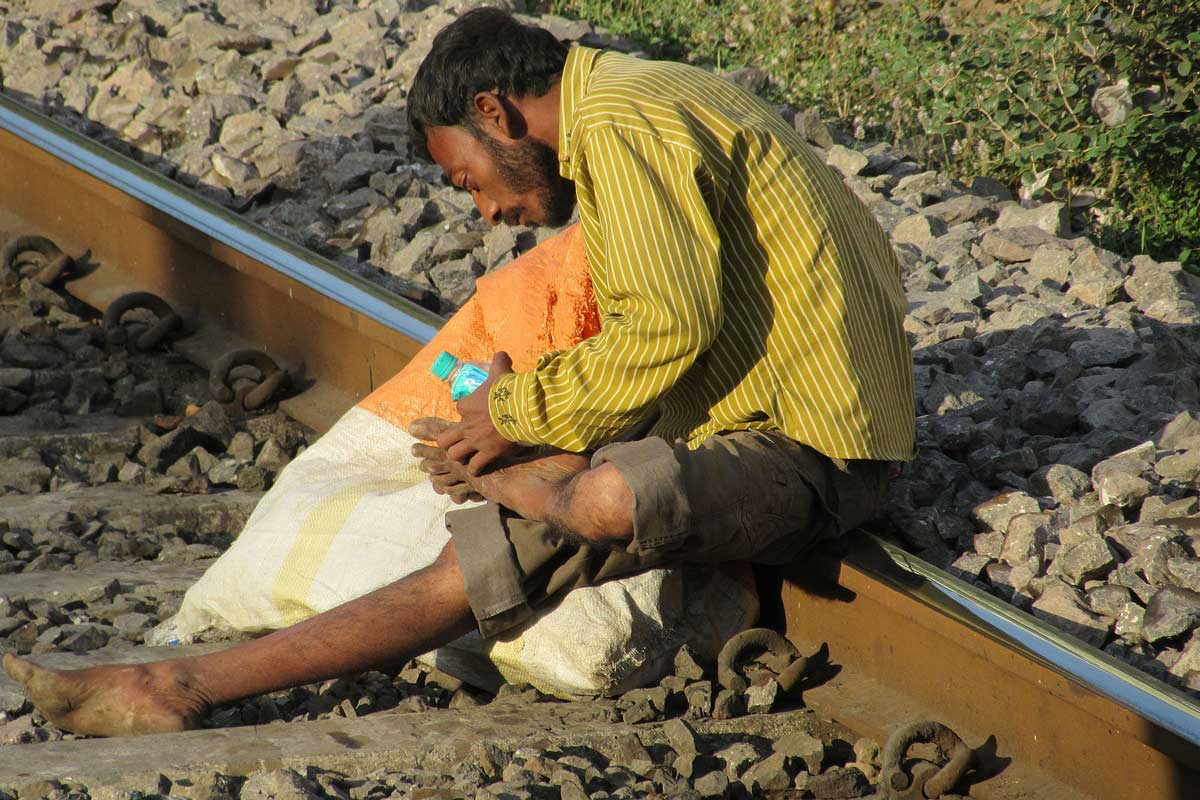 Waste picker cleaning his wounds on the suburban railway track in Mumbai. Image: Hamsa Iyer (CC BY-SA 4.0).