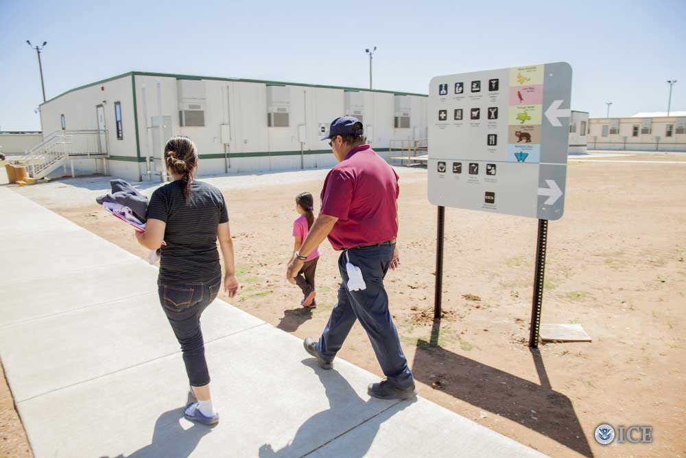 Residents walk past campus map at the STFRC in Dilley, Texas. Credit: Charles Reed, U.S. Immigration and Customs Enforcement