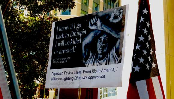 A poster of Olympic silver medallist Feyisa Lilesa at a protest in Oakland, California. Making the crossed arm gesture is now a criminal offense under Ethiopia’s state of emergency. Credit: Elizabeth Fraser.