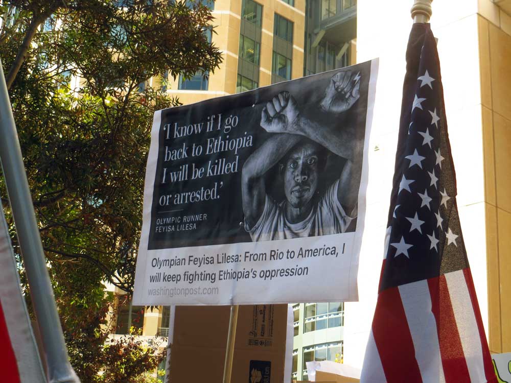 A poster of Olympic silver medallist Feyisa Lilesa at a protest in Oakland, California. Making the crossed arm gesture is now a criminal offense under Ethiopia’s state of emergency. Credit: Elizabeth Fraser